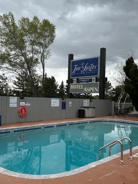 a large swimming pool with a hotel agent sign at Hotel Aspen Flagstaff/ Grand Canyon InnSuites in Flagstaff