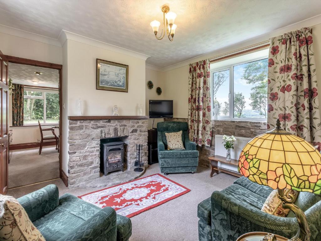 a living room with couches and a fireplace at Steep Holm in Kington