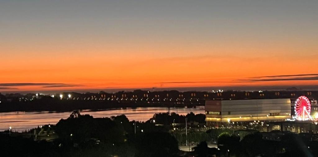 a building with a ferris wheel in front of a sunset at LA VISTA MAS MARAVILLOSA DE CONCEPCION, ubicación perfecta, precio buenisimo, hermoso y comodo departamento in Concepción