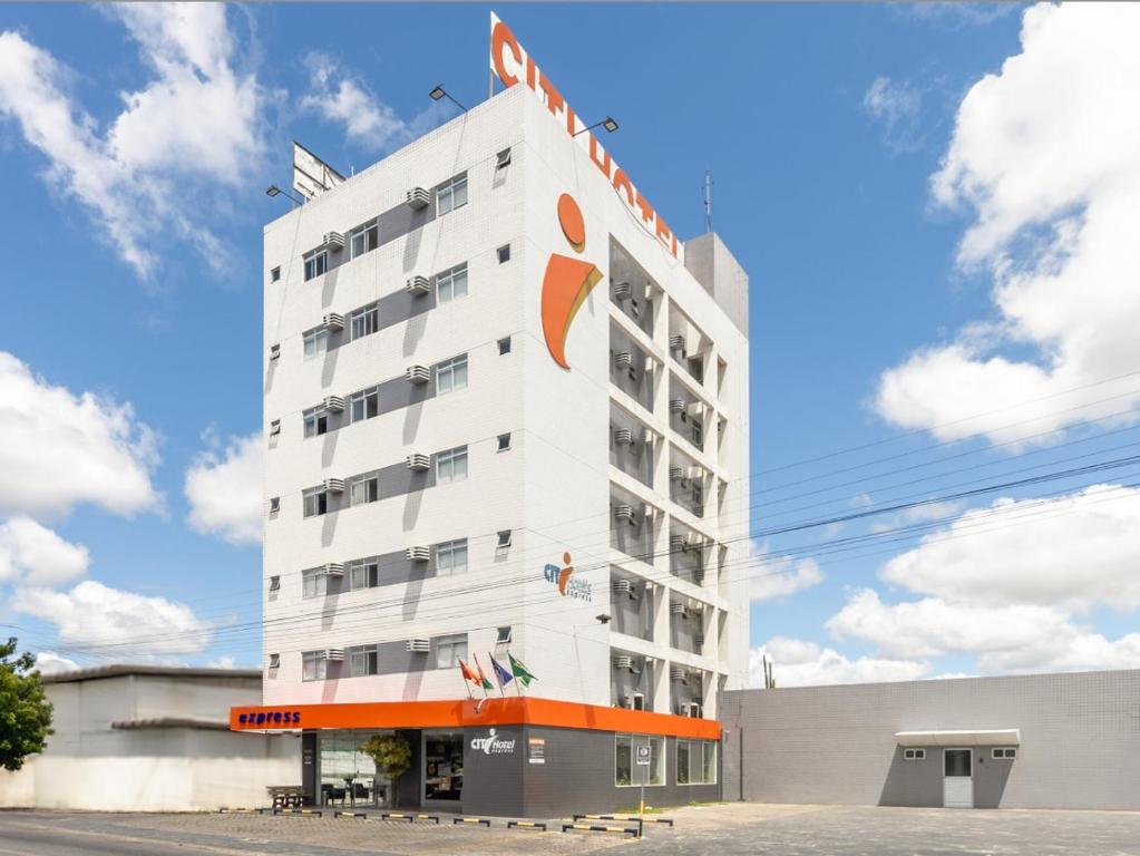 a hotel with an orange sign on the side of it at Citi Hotel Express Caruaru in Caruaru