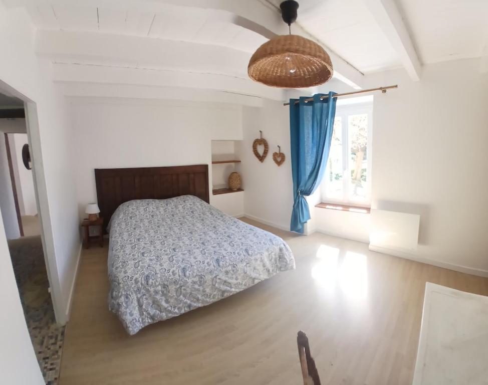 a white bedroom with a bed and a window at Le Gîte de la Gartempe in Saint-Sornin-la-Marche