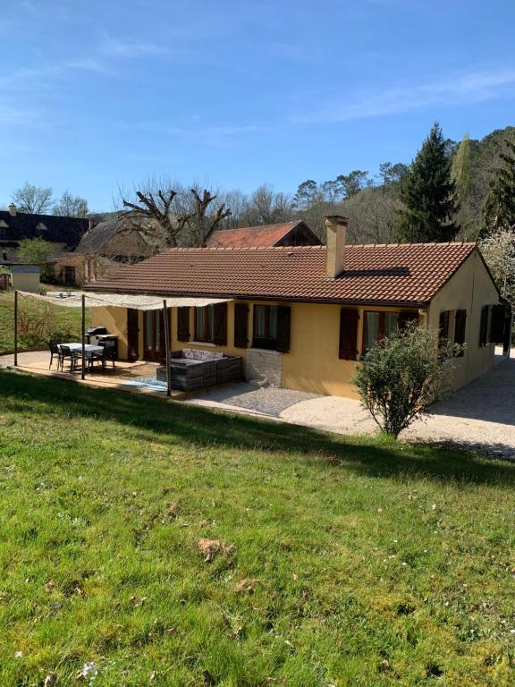a small yellow house with a grass field at Gîte l'Arbre de vie 24 in Nabirat