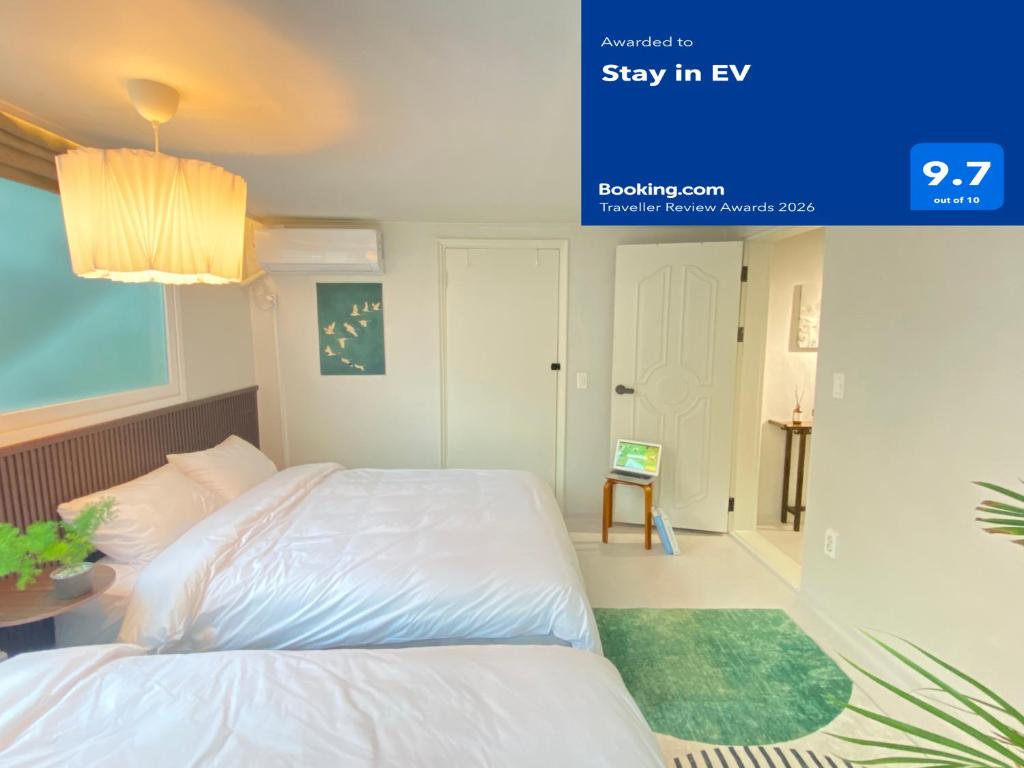 a bedroom with a white bed and a blue screen at Stay in EV in Seoul