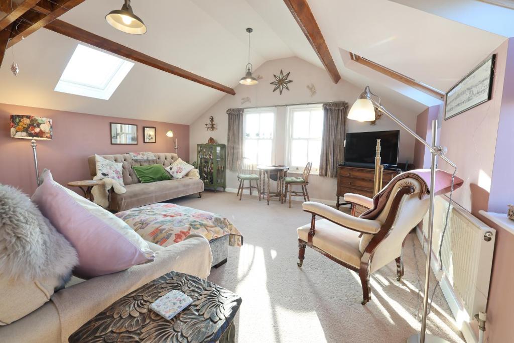 a living room with a couch and a table at Harbour View Penthouse in Lowestoft