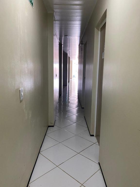 an empty hallway with white tile floors and walls at Pousada Medeiros in Cedro