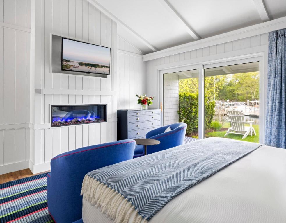 a bedroom with a bed and chairs and a tv at Yachtsman Lodge & Marina in Kennebunkport