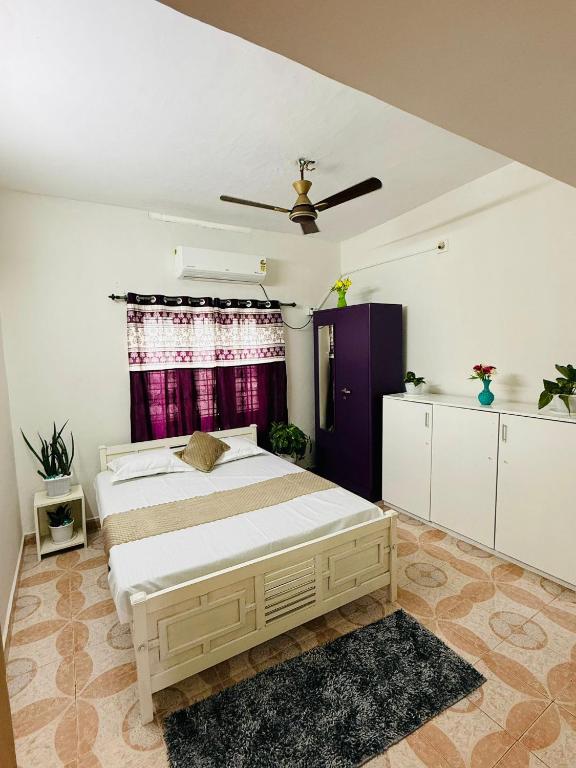 a bedroom with a bed and a ceiling fan at Jimmy nivas in Kottayam