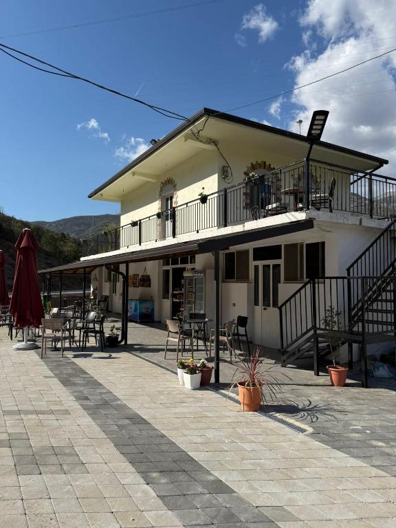 a building with tables and chairs in front of it at Antoni Guest House & Café in Lekaj