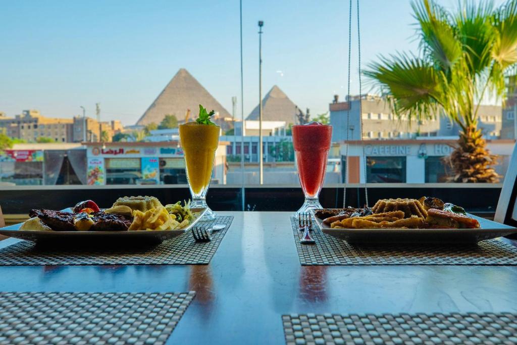 a table with two drinks and two plates of food at The Muse Luxury View Hotel in Cairo