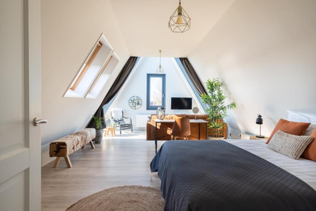a bedroom with a bed and a desk in a room at Yn 'e Haven Logies in Earnewâld