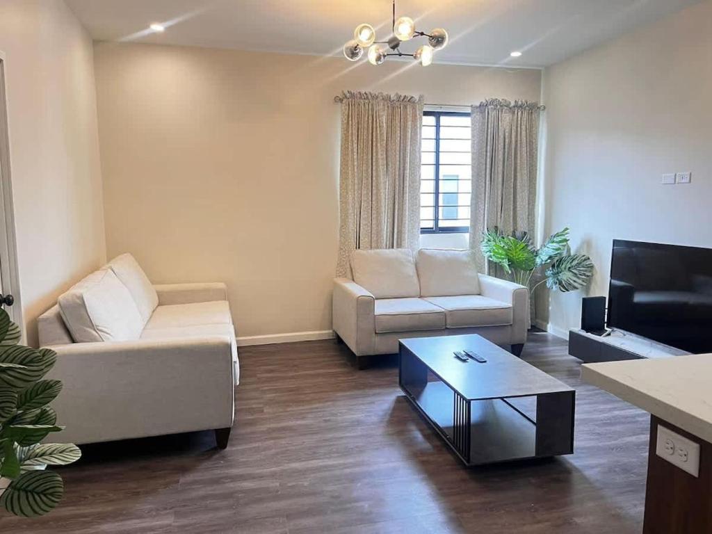 a living room with two couches and a tv at Executive 1BR Downtown POS with ensuite bath in Port-of-Spain