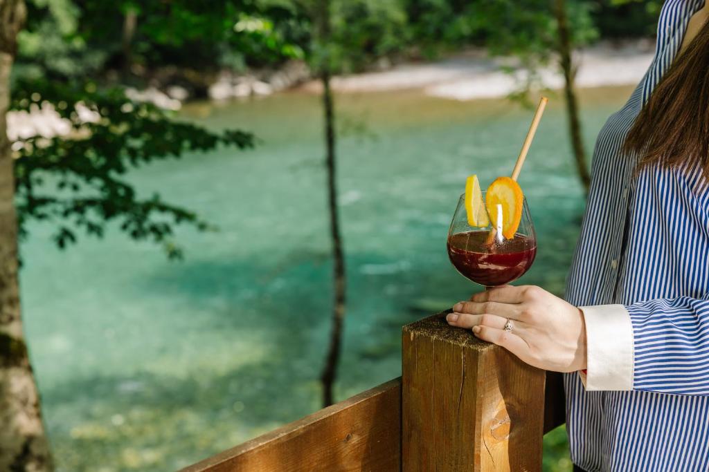 a woman is holding a glass of wine at Hotel Porto Tara in Žabljak