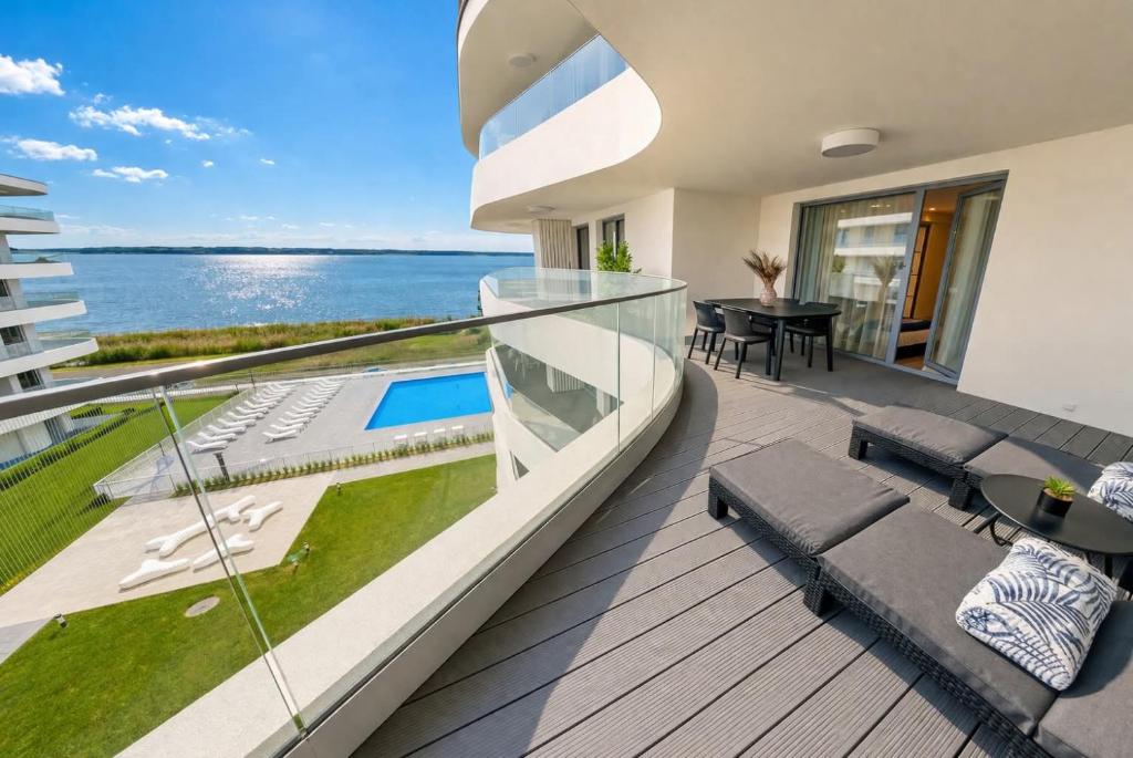 a house with a balcony with a view of the ocean at Apartament Sapphire Rogowo Pearl in Mrzeżyno