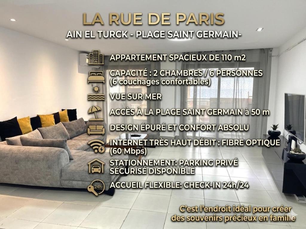 a living room with a couch and a wall with the words larue de pens at Rue de Paris - Plage Saint Germain - vue sur mer - in Aïn El Turk