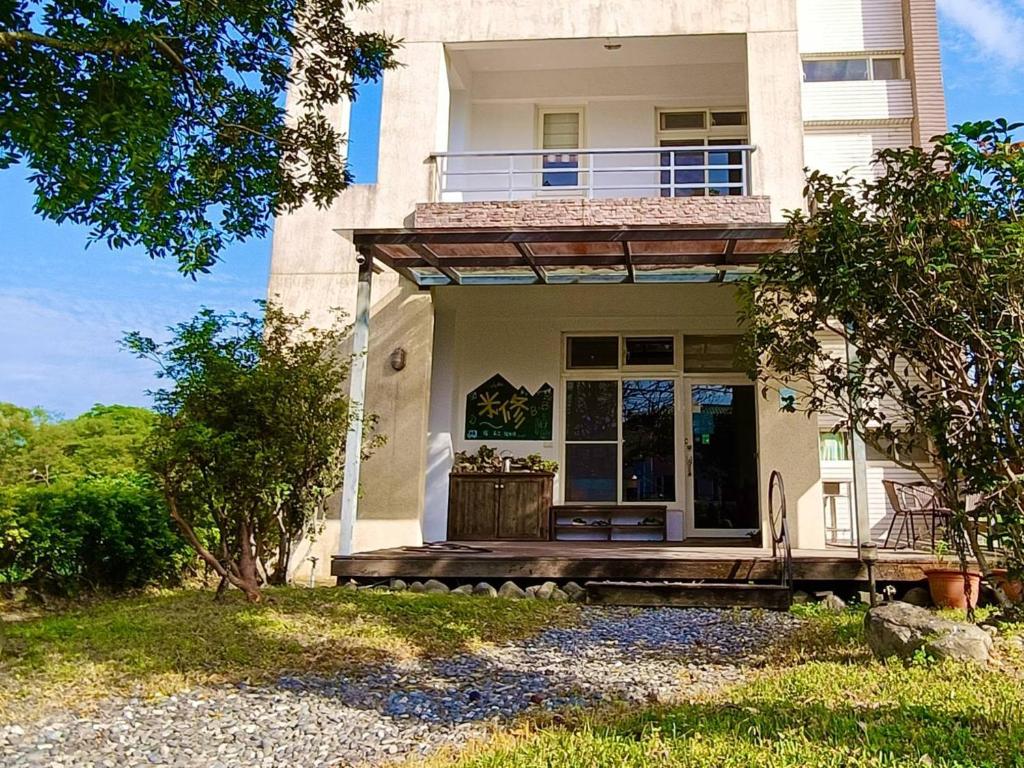 a white house with a porch and a balcony at Mei Shiou B&B in Dongshan