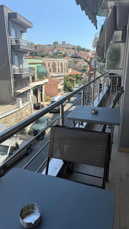 a table and chairs on a balcony with a view of a city at Castle view 2 in Kavála