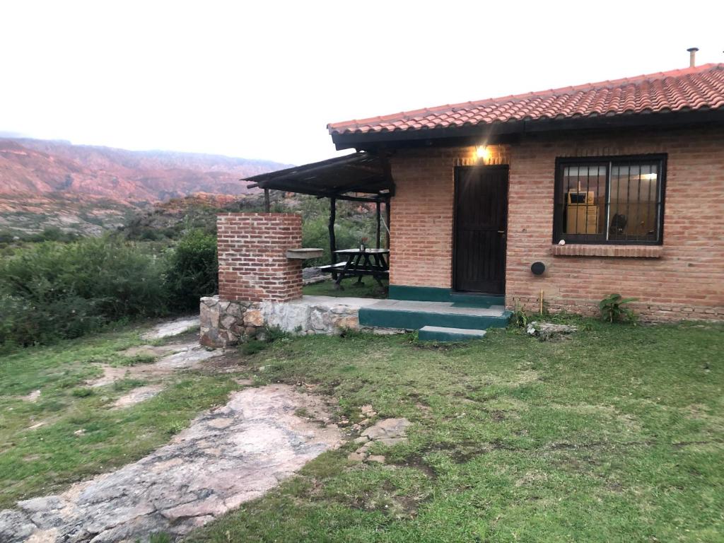 a brick house with a picnic table in front of it at Hermosa Cabaña El Nogalito Mina Clavero in Mina Clavero