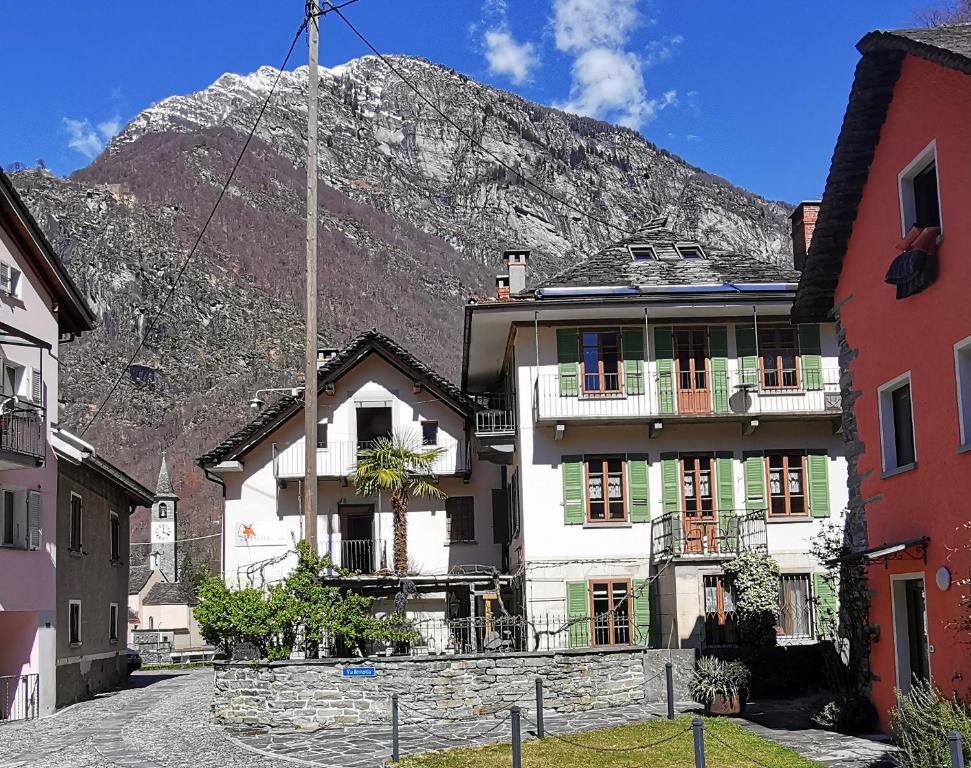 a building with a mountain in the background at Garni Cà Stella in Bignasco