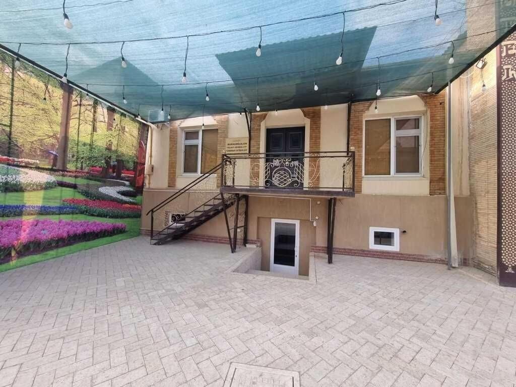 a large building with a staircase and a patio at Bobo Haydar FREE LONDRY SERVICE in Bukhara