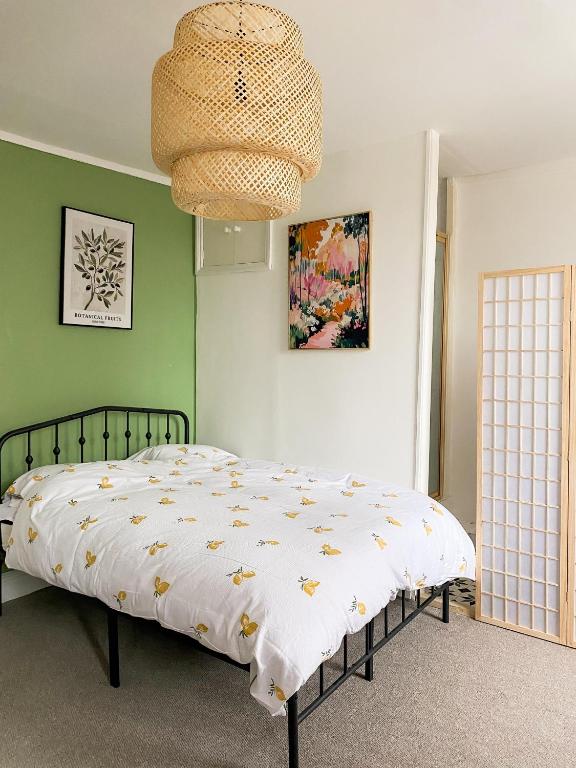 a bedroom with a bed and a chandelier at Cozy en suite room in King's Lynn