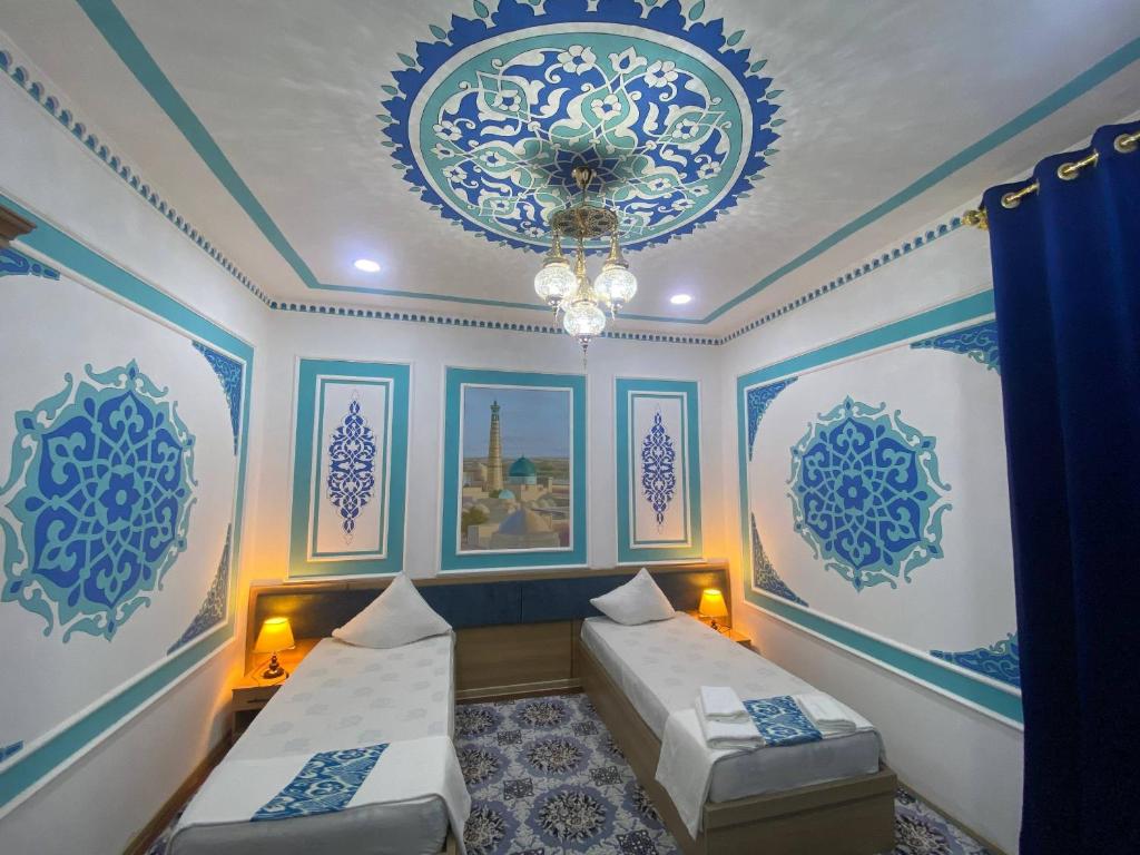 a room with two beds and blue and white walls at Gavhar Boutique Hotel in Khiva