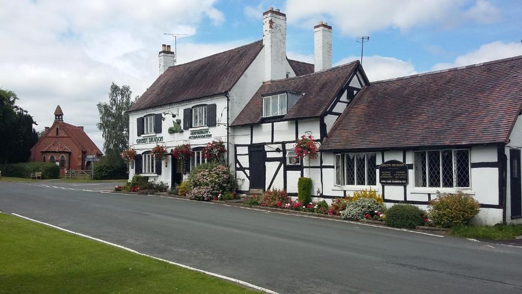 a white and black house with flowers on a street at The Green Dragon Inn in Redditch