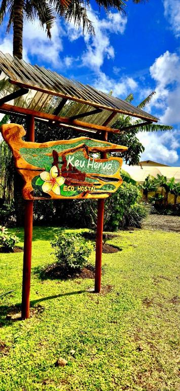 a wooden bench sitting in the grass in a field at KeuhenuaEcoHostal in Hanga Roa
