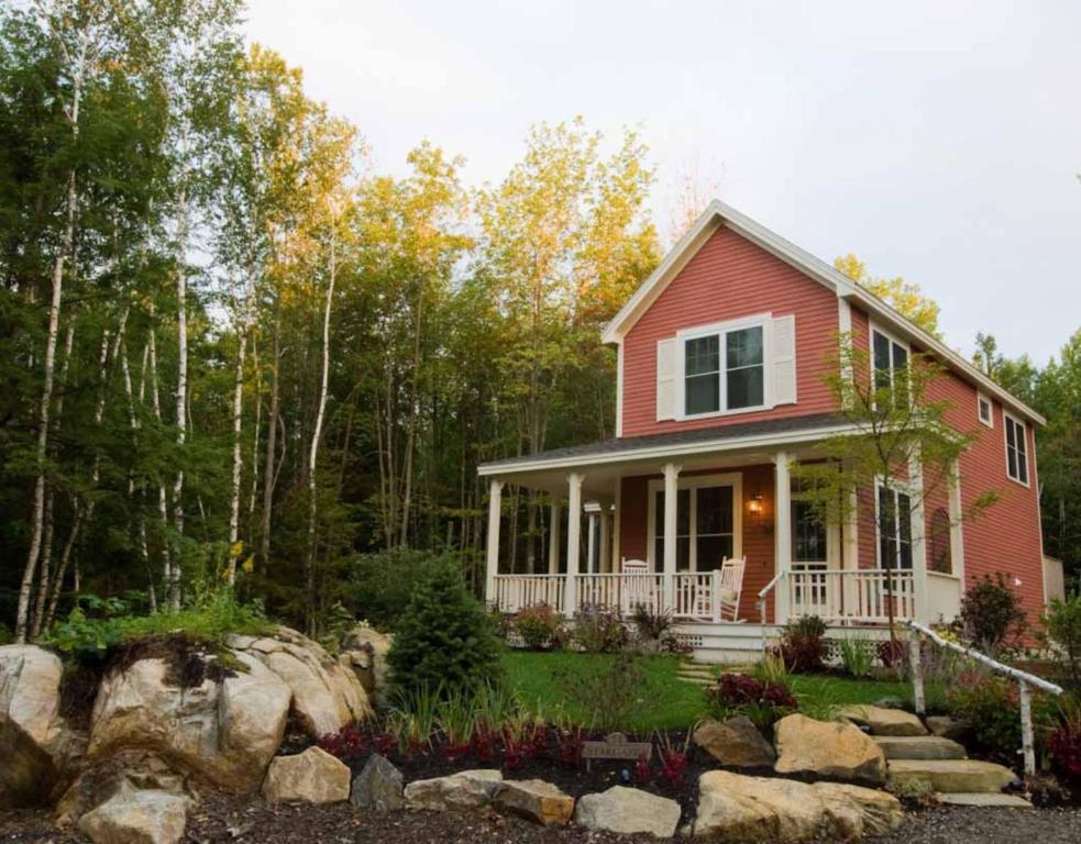 a red house with a rock garden in front of it at Hidden Pond Resort in Kennebunkport