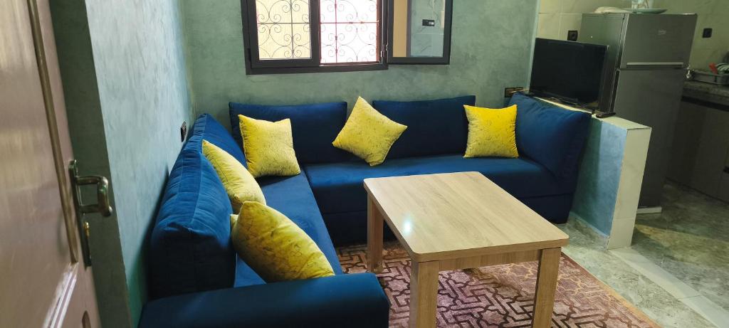 a blue couch with yellow pillows in a living room at Tata hôte in Tatta