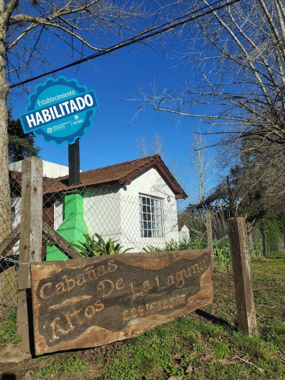 a sign in front of a white building with a sign at Altos de la Laguna in Chascomús
