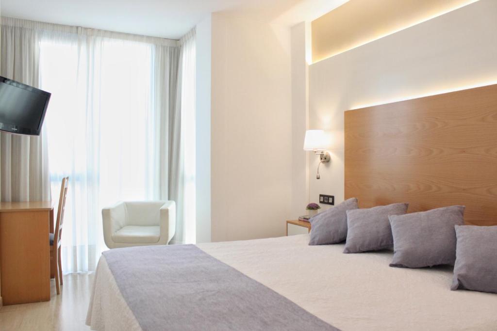 a bedroom with a large bed and a television at Hotel La Noyesa *** Superior in O Grove