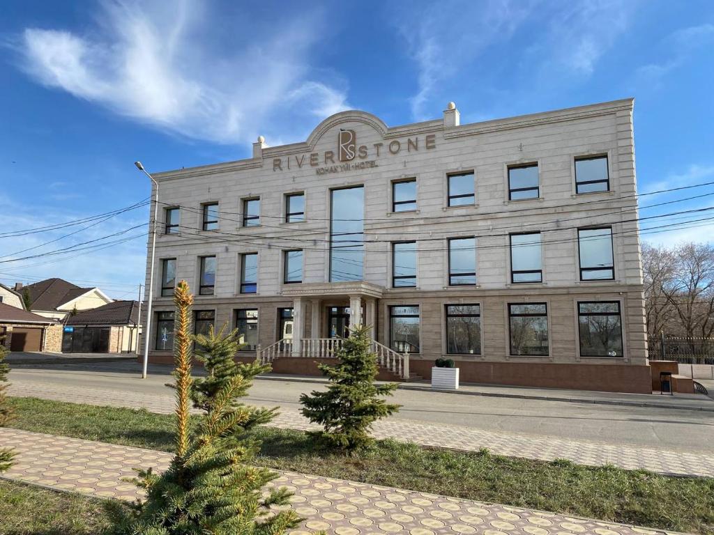 a large building with a sign on the front of it at River Stone in Pavlodar