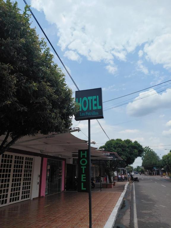 a sign for a hotel on the side of a street at Hotel Los Potrillos in Aguazul