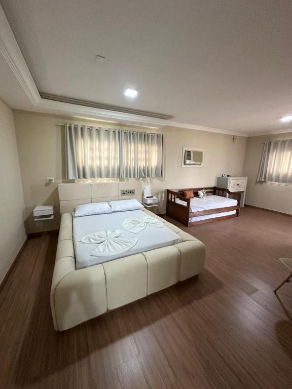 a large bedroom with a large bed in a room at Johnnys motel hotel in Jacarèzinho
