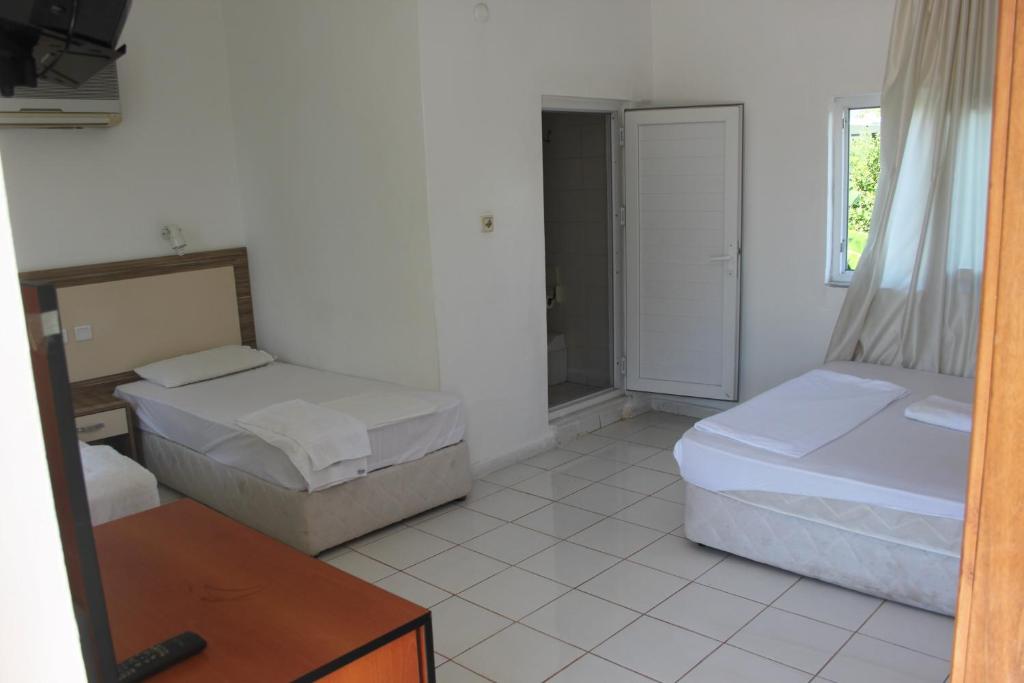 ein Schlafzimmer mit zwei Betten, einem Tisch und einem Spiegel in der Unterkunft Ünal Boutique Hotel in Kemer