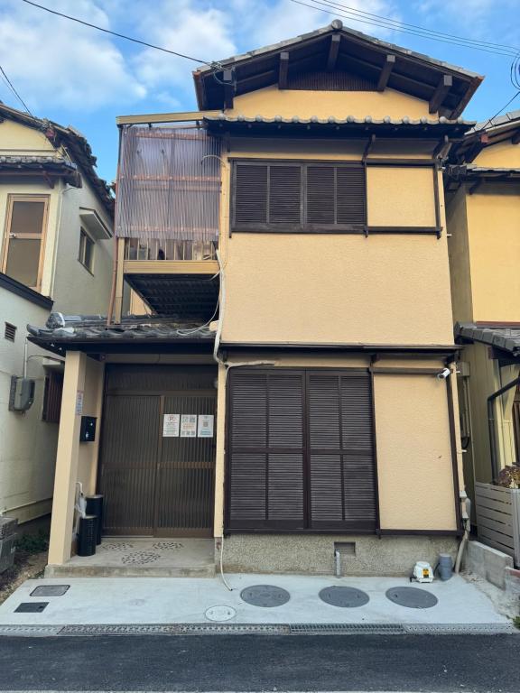 a house with two garage doors in a street at 羽憩館 Hakeikan KIX in Izumi-Sano