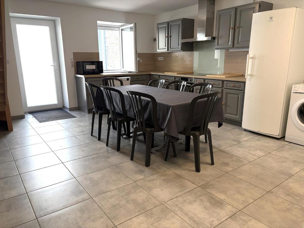 a kitchen with a table and chairs and a refrigerator at Chardonnay in Boyeux-Saint-Jérôme