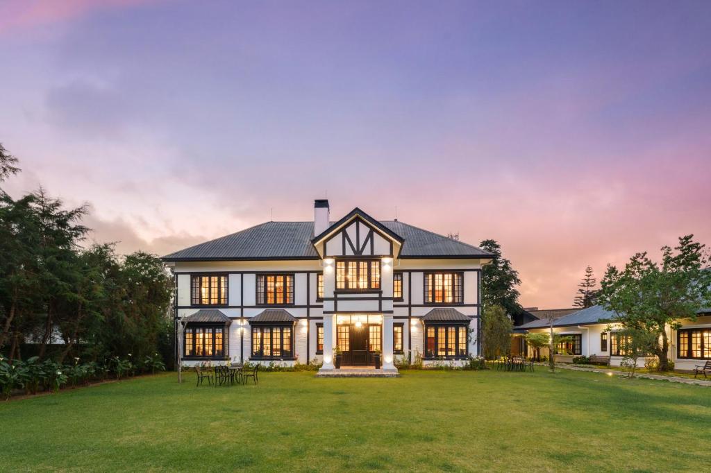 an exterior view of a large house with a lawn at Chimneys Nuwara Eliya in Nuwara Eliya