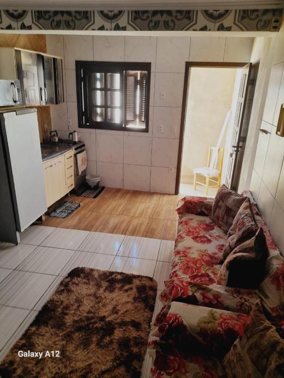 a living room with a couch and a kitchen at Duplex 2 quartos pertinho da Praia in Tramandaí