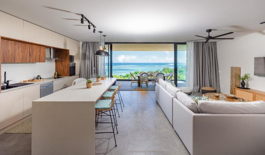 a kitchen and living room with a couch and a table at Panoramic View Mauritius in Ruisseau Créole