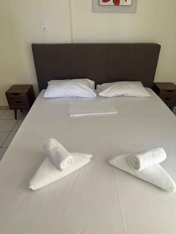 a white bed with two rolled towels on it at Luxury Beach House 2 in Xiropigado