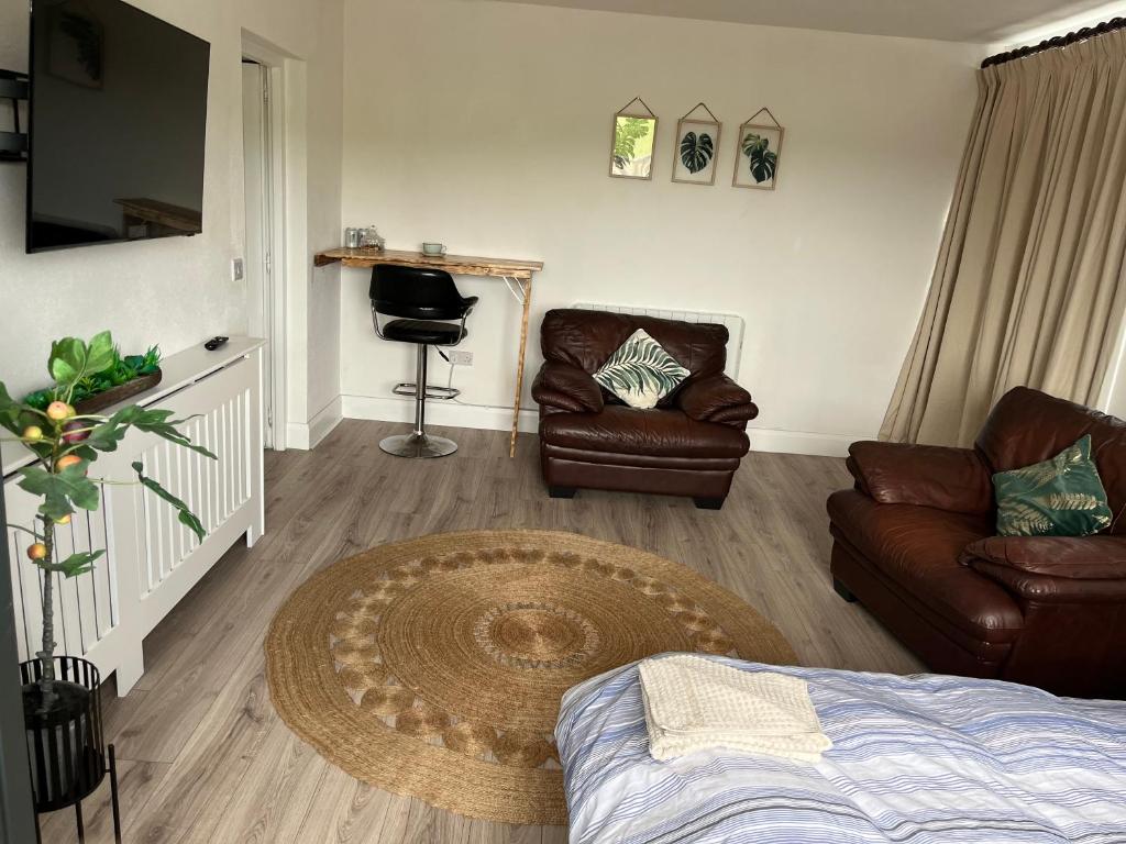 a living room with a couch chair and a table at The C & A Studio in Killala