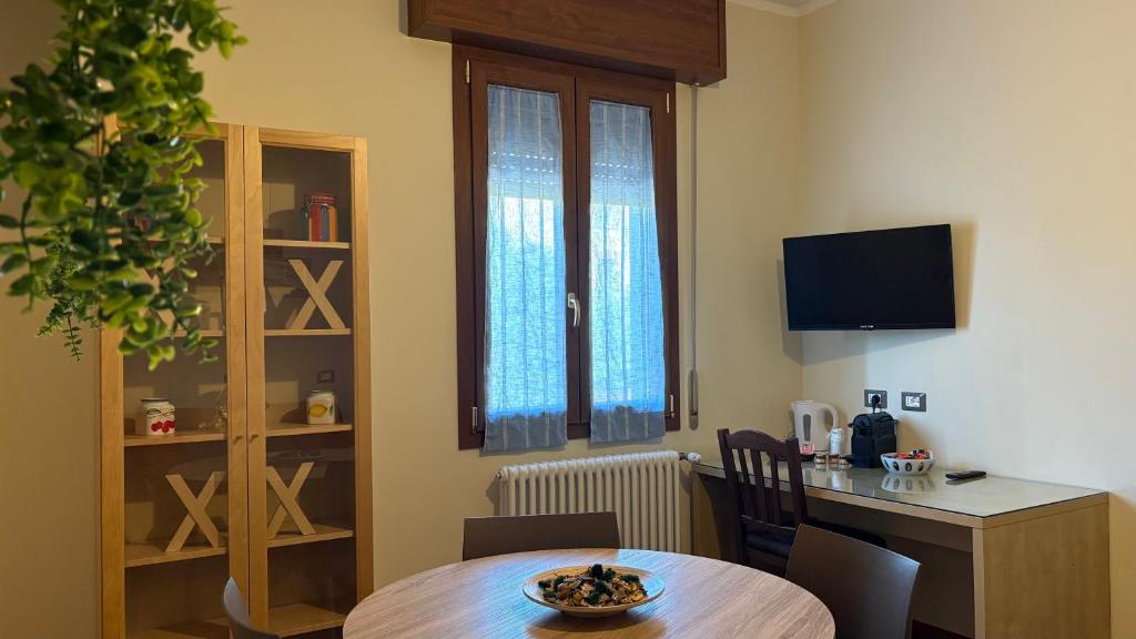a room with a table and a kitchen with a desk at Suites Asia in Argelato