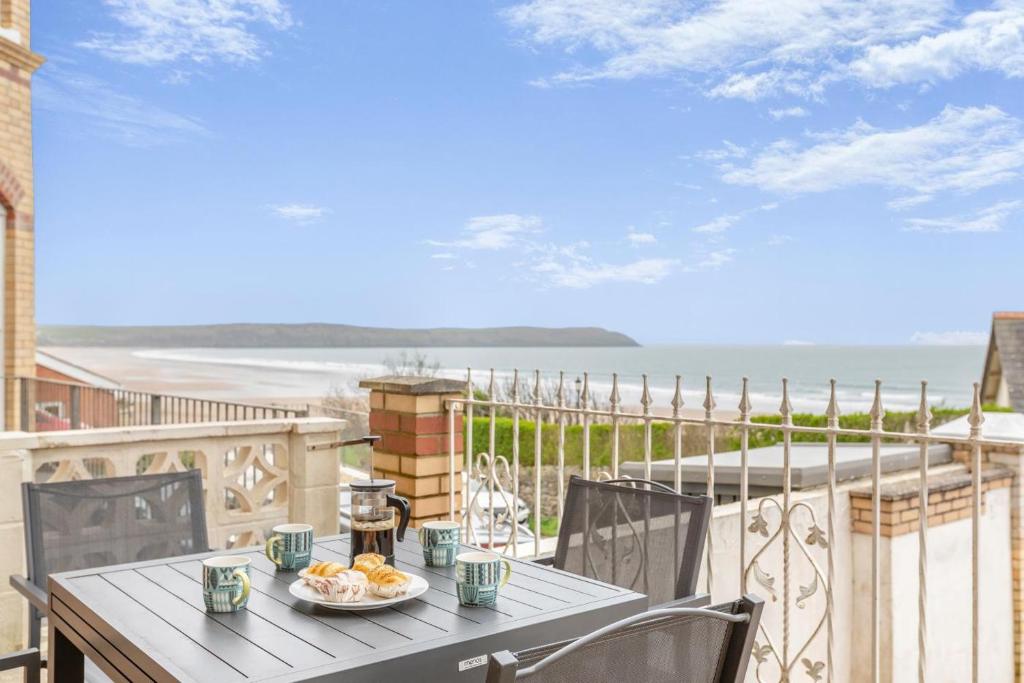 a table on a balcony with a view of the ocean at 2 Bed in Woolacombe oc-dolph in Woolacombe