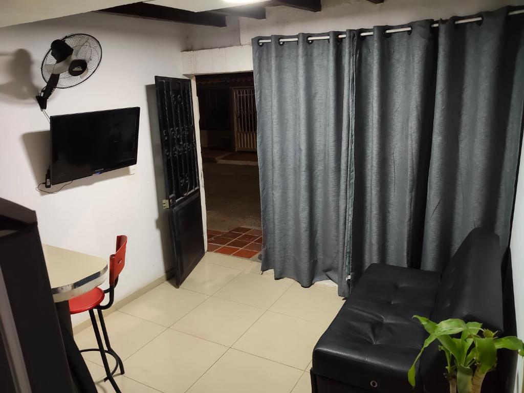 a living room with a couch and a television at Apartaestudio con Parqueadero in Cúcuta