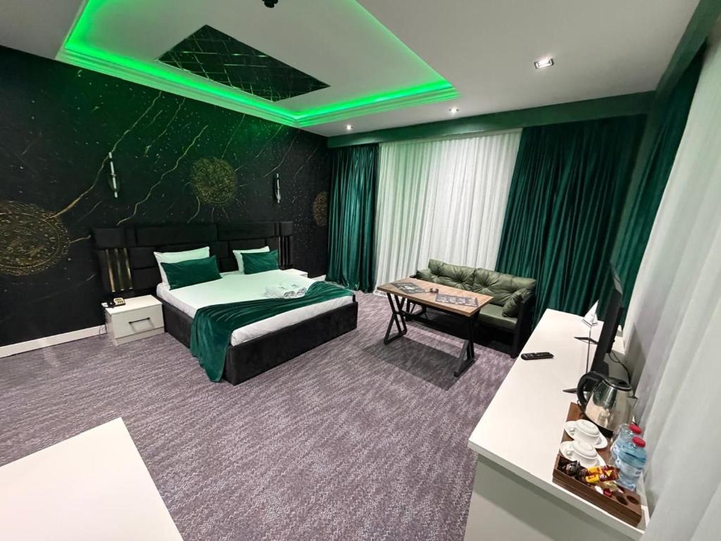 a hotel room with a bed and a couch and green lights at Bazarstore Montin Hotel in Baku