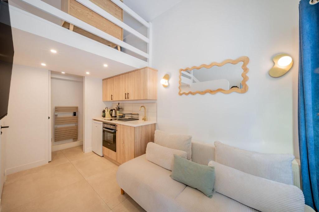 a living room with a couch and a kitchen at Studio in a residence with pool - Saint-Tropez in Saint-Tropez