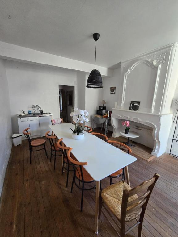 a dining room with a white table and chairs at B&B Le MONSEG 33 in Monségur