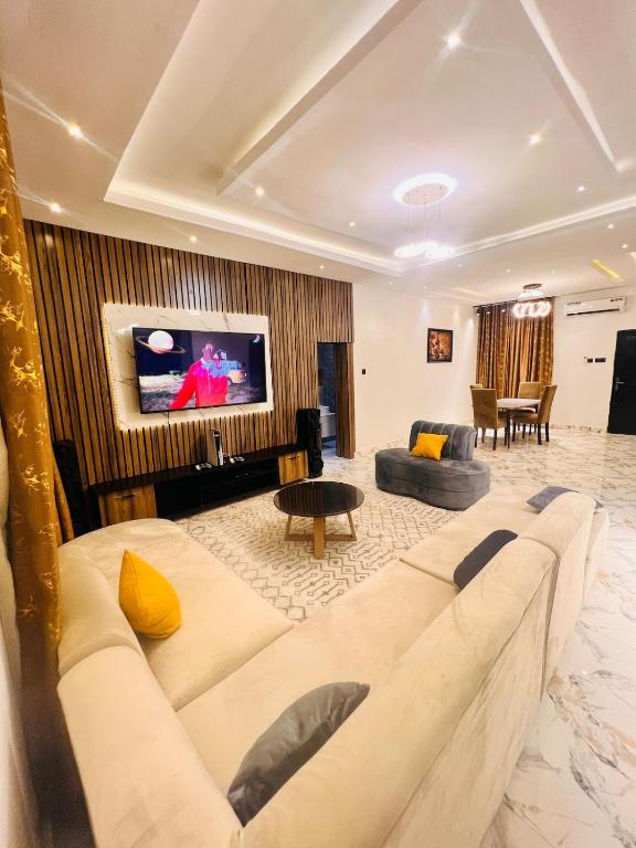 a living room with a couch and a tv at 3BED flat close to the airport lagos in Lagos