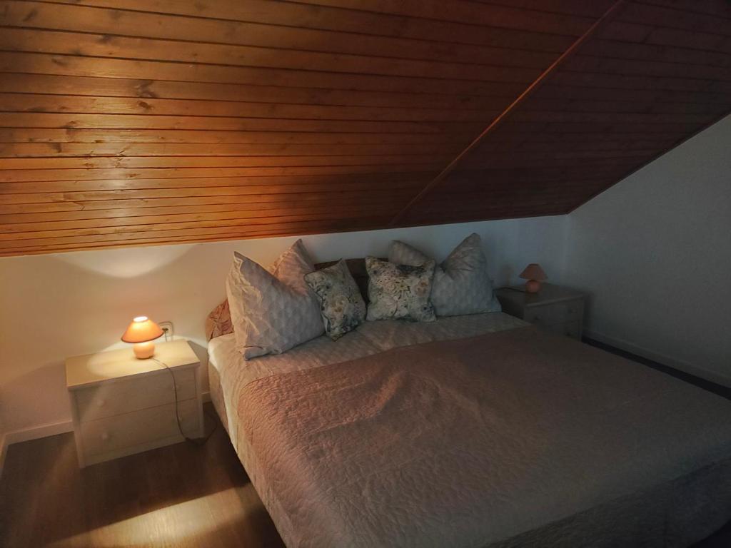 a bedroom with a bed with a wooden ceiling at Csengi Apartman in Balatonszárszó